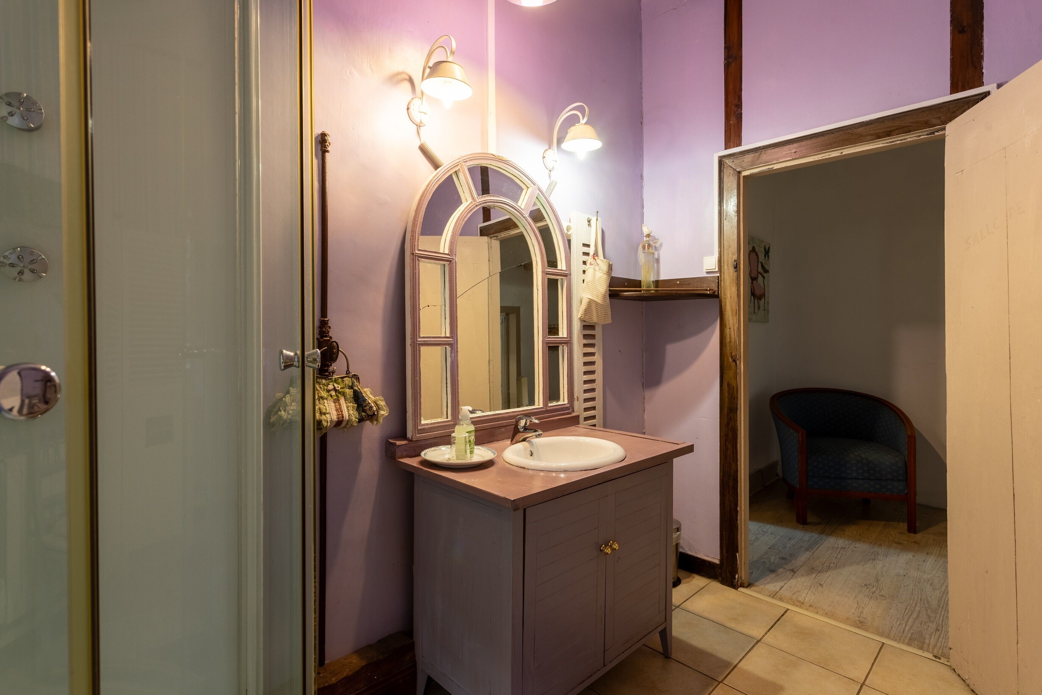 A bathroom with a vanity, mirror, and two wall-mounted lights.