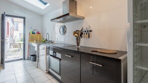 A modern kitchen with a skylight, stainless steel appliances, and a knife block.