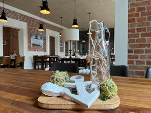 A wooden table with decorative items including a glass bottle, an anchor, and two spherical objects. - Hotel Alte Navigationsschule (Rhauderfehn)