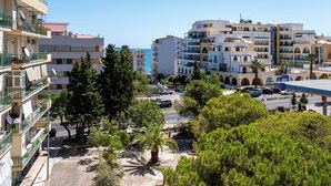 Ein Küstenort mit mehrstöckigen Gebäuden, einem Parkplatz und freiem Blick auf das Meer.