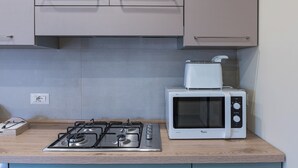 Eine Küche mit Gasherd, Mikrowelle und Holzarbeitsplatten.