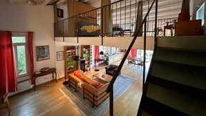 A spacious loft with a high ceiling, a mezzanine level, and a staircase. - Villa Manghisi with Private Pool, Wi-Fi and Air Conditioning (Noto)