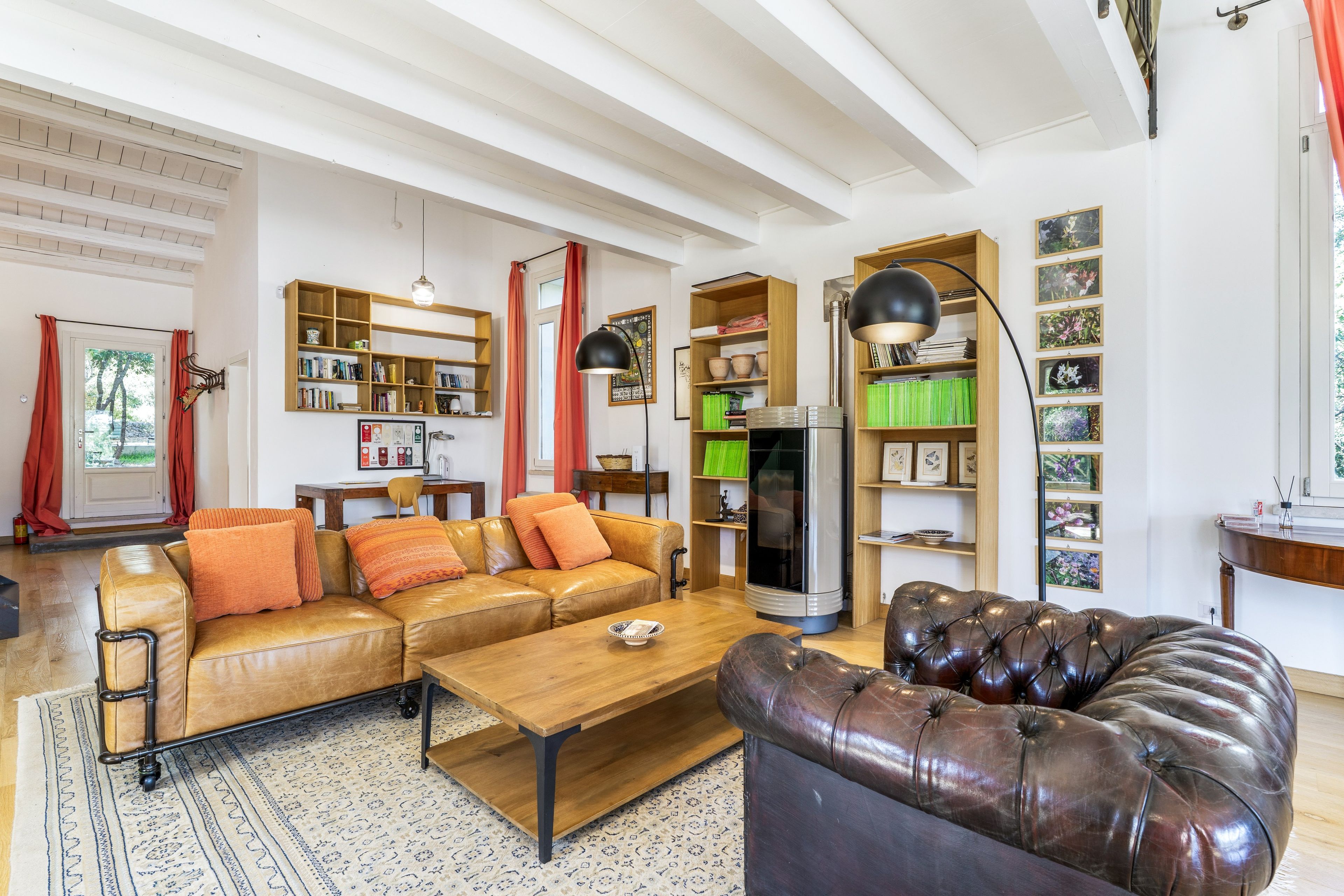 Ein Wohnzimmer mit einer Couch, einem Couchtisch, einem Ledersessel und einem Bücherregal.