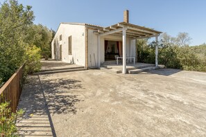 A single-story building with a covered outdoor seating area and a paved driveway.