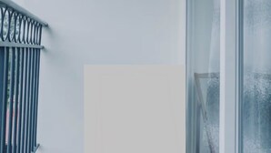 A balcony with a metal railing, a large window, and a white wall. - VEE LUX BNB

Thindigua Finest (Nairobi)
