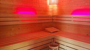 A sauna with wooden benches and a central heating element. - Hotel Schützenhof mit Wellness  (Buerstadt)