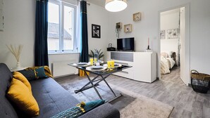 Ein modernes Wohnzimmer mit einer Couch, einem Esstisch und einer Küchenzeile.