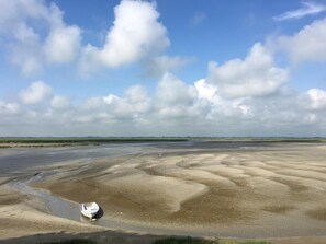 A wide, flat landscape with a boat on the shore and a distant horizon. - Holiday Home “Gîte La Briqueterie 3 Épis” with Private Terrace, Garden & Wi-Fi (Quesnoy-le-Montant)