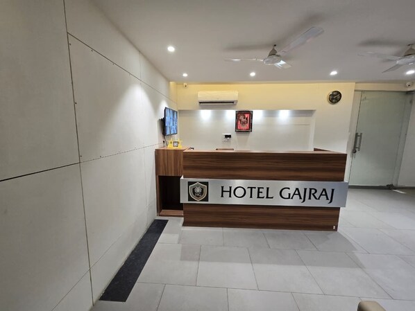 A reception desk with a sign reading 'HOTEL GAJRAJ' and a logo above it. - GAJRAJ HOTEL (Vadodara)