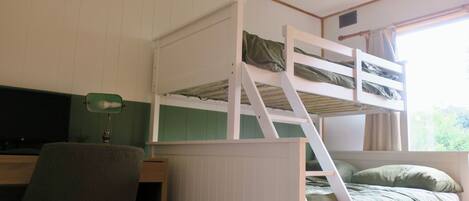 Een stapelbed met een bureau en stoel, een raam met gordijnen, en een groene wand.