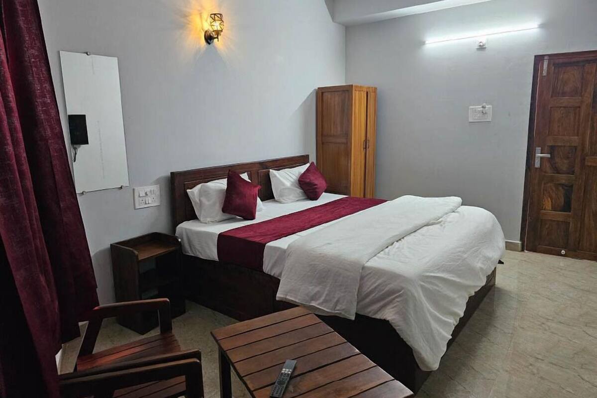 Ein Schlafzimmer mit Bett, Nachttisch, Holzschrank und Wandleuchte.