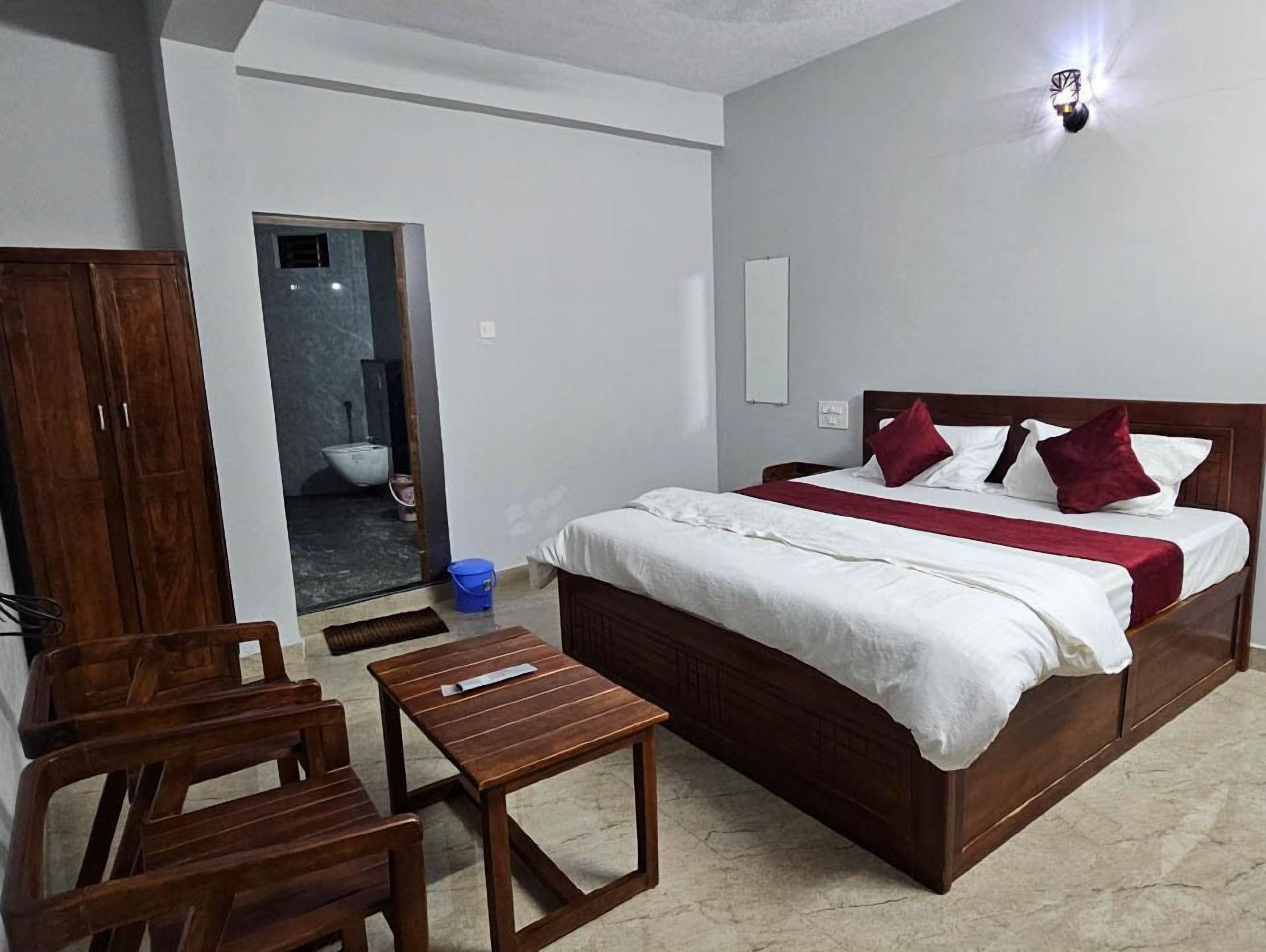 Ein Schlafzimmer mit einem Bett, Holzmöbeln, einem kleinen Tisch und einem Kleiderschrank.