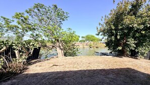 A dry, sandy area with trees and a body of water. - Casa Granero, Waterfront 3BD/2BA w/ Private Yard! (Brownsville)