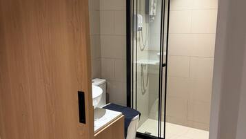 Un baño moderno con ducha, inodoro y lavabo.