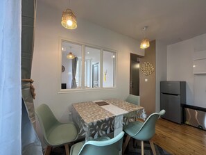 Un espace repas comprenant une table, des chaises et un réfrigérateur.