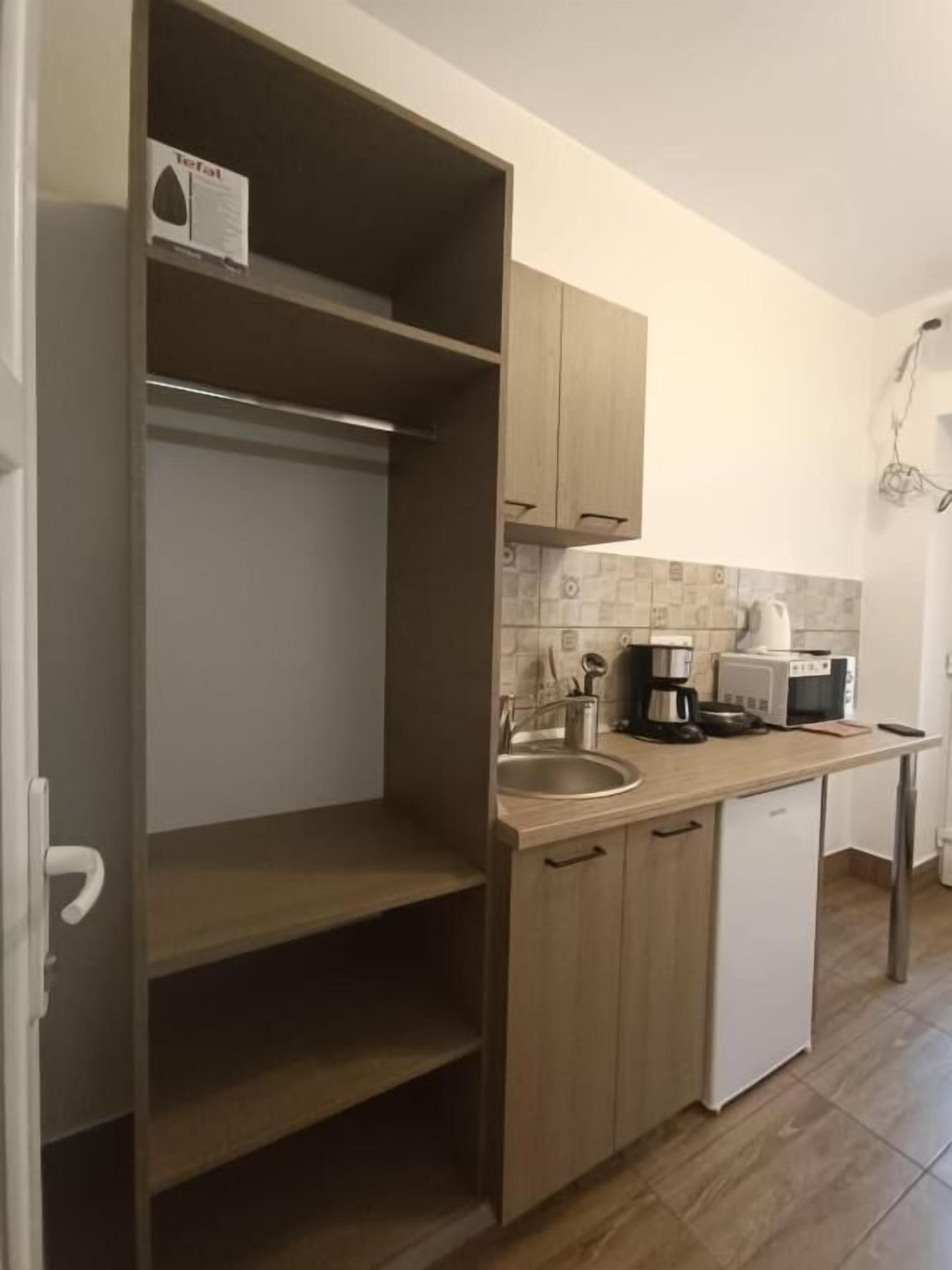 A compact kitchen with a built-in dishwasher, a coffee maker, and a microwave.