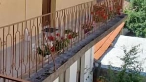Un bâtiment jaune doté d’un balcon, d’une porte et d’une fenêtre.
