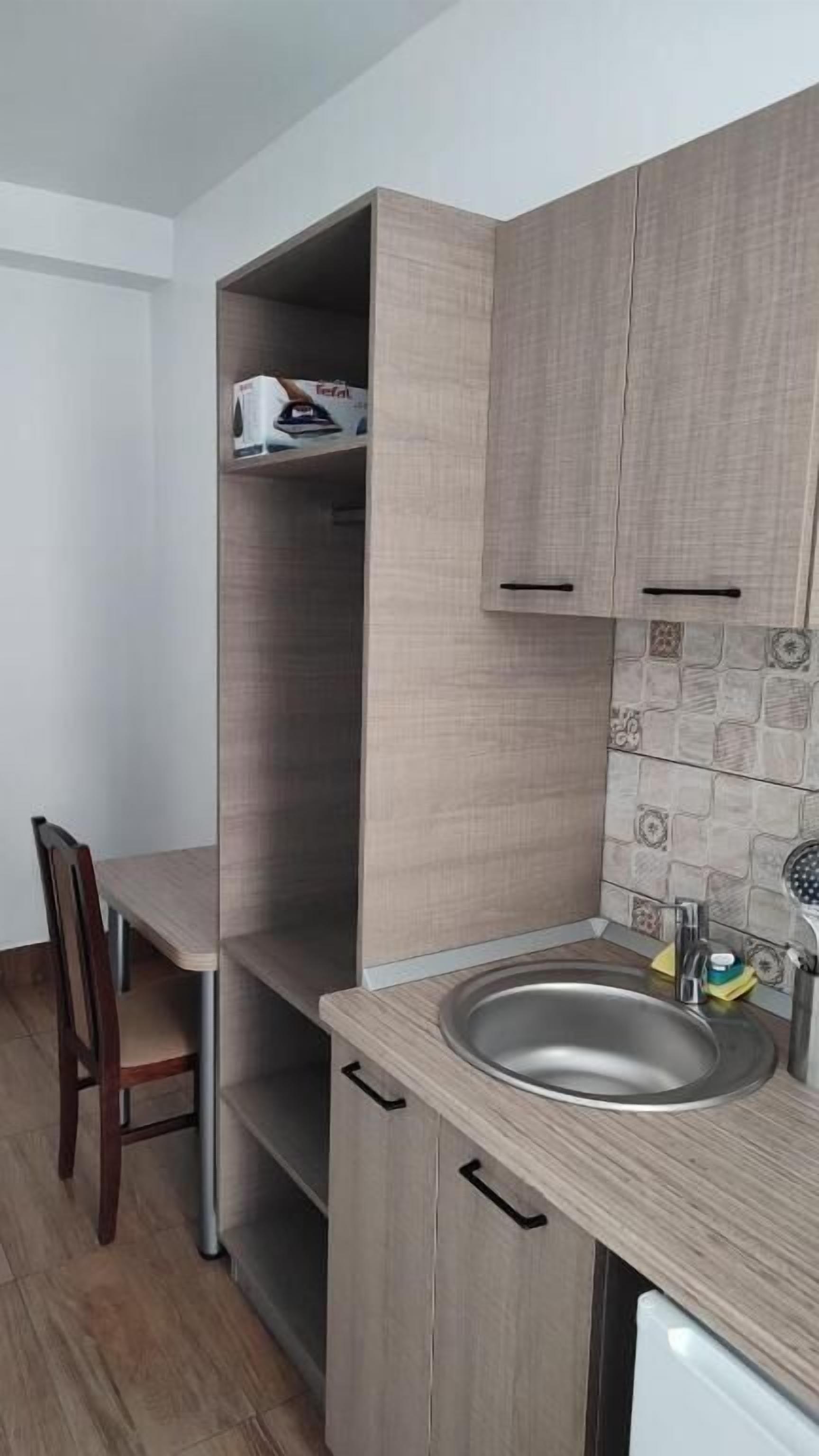 Una cocina con encimera de madera, un lavabo y una silla.