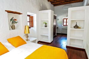 Ein Schlafzimmer mit einem Bett, einem Nachttisch, einer Lampe und einem Regal mit Dekoration.