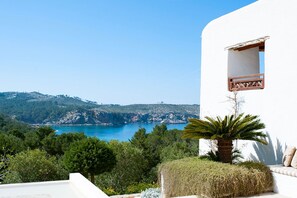 Un bâtiment blanc doté d’un balcon donnant sur un paysage côtier.