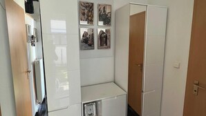 A modern kitchen with white cabinets, a built-in oven, and a clock on the wall. - Vacation apartment in Bönnigheim, detached house near Tripsdrill adventure park (Bönnigheim)