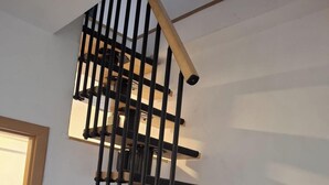 A spiral staircase with a black railing and wooden steps. - Vacation apartment in Bönnigheim, detached house near Tripsdrill adventure park (Bönnigheim)