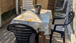A patio with a table and chairs, a wooden fence, and a potted plant. - Vacation apartment in Bönnigheim, detached house near Tripsdrill adventure park (Bönnigheim)