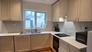 Eine Küche mit Fenster, Spüle, Herd und Kühlschrank.