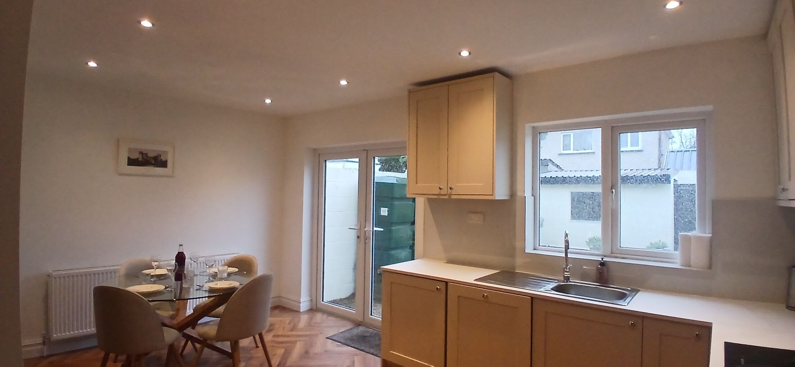 A compact kitchen with a dining area, a window with a view, and a radiator.
