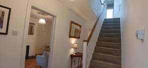 A staircase with a wooden handrail leading to an upper floor. A small table with a lamp is placed near the stairs. - Fresh Stylish 3BDR Home with Garden Near City (Dublin)