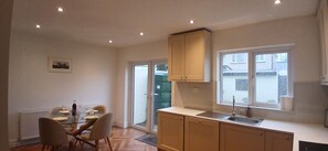 Una cocina compacta con comedor, una ventana con vistas y un radiador.