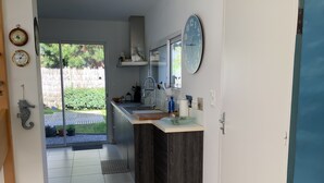 Eine moderne Küche mit einem großen Fenster, einer Spüle und einer Uhr an der Wand.