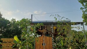 A rustic wooden gate leading to a property with a signboard advertising rent. - Beautiful 3-bedroom villa with AC in charming Phú Quốc (PHÚ QUỐC)