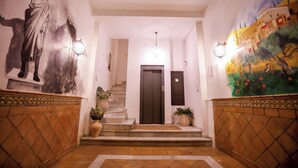 A hallway with a mural, a statue, a staircase, and a door. - THE HOUSE OF CLUDIO MARCELO (Córdoba)