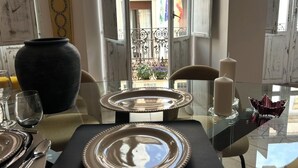 A dining table set with plates, cutlery, and a vase. - THE HOUSE OF CLUDIO MARCELO (Córdoba)