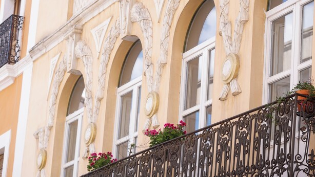 A building facade with arched windows, decorative moldings, and a balcony with wrought iron railing. - THE HOUSE OF CLUDIO MARCELO (Córdoba)
