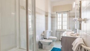 Une salle de bain avec une douche, des toilettes, un lavabo et un tapis bleu.