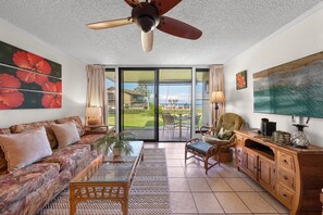 A living room with a sofa, armchair, coffee table, and TV stand. - SUMMER SALE! Ocean View Paradise,1BR condo in Lahaina - Polynesian Shores 106 (Lahaina)