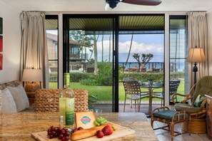 A dining area with a table set for two, featuring a bottle of wine, cheese, grapes, and strawberries. - SUMMER SALE! Ocean View Paradise,1BR condo in Lahaina - Polynesian Shores 106 (Lahaina)
