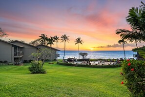 Ein Resort mit Pool, Palmen und Blick auf den Sonnenuntergang.