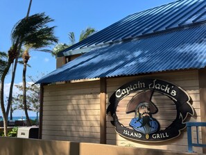 A wooden building with a corrugated metal roof and a sign that reads "Captain Jack's Island Grill". - SUMMER SALE! Experience Oceanfront luxury in West Maui! - Polynesian Shores 224 (Lahaina)