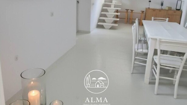 A modern interior with a staircase, a dining area, and a kitchen. - Alma-Chalet di Lago (Capodimonte)