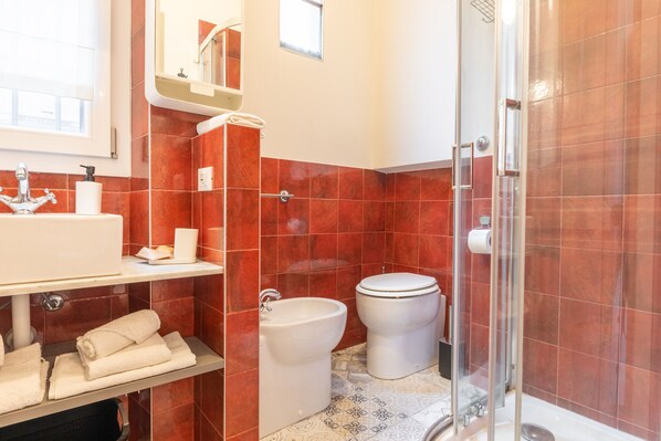 Ein Badezimmer mit Waschbecken, Toilette, Bidet und Dusche.
