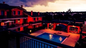 Ein Wohnhaus mit Schwimmbad, überdachter Terrasse und Blick auf die Nachbarschaft.
