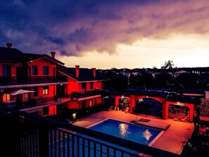 Ein Wohnhaus mit Schwimmbad, überdachter Terrasse und Blick auf die Nachbarschaft.