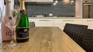 Eine moderne Küche mit weißen Schränken, einer Edelstahl-Dunstabzugshaube und einem Holztisch.
