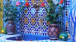 A tiled wall with a mosaic pattern, a water feature, and potted plants. - Riad Allal (Marrakech)