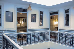 A multi-level interior with a balcony, ornate railings, and framed artwork on the walls. - Riad Allal (Marrakech)