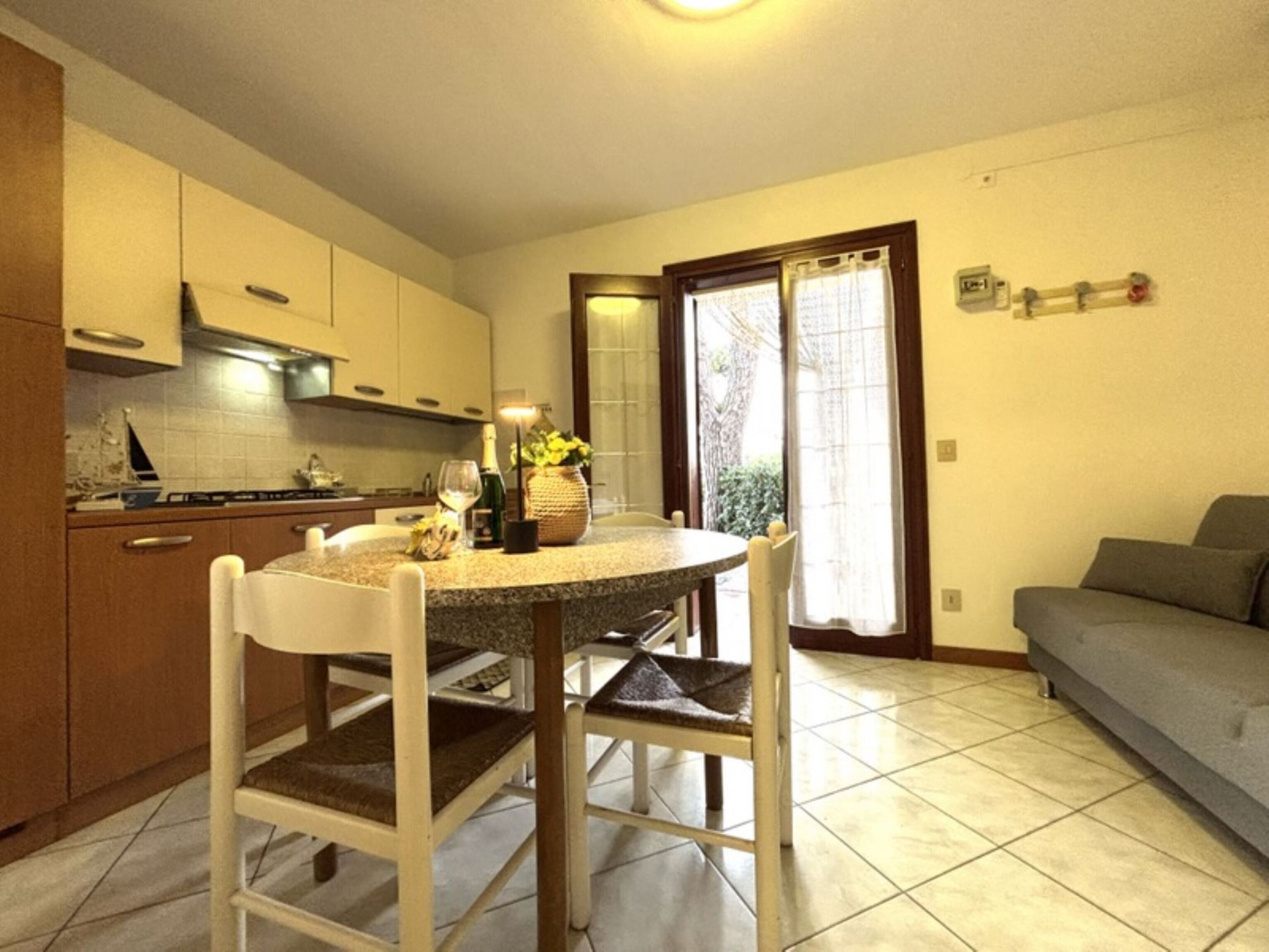 A compact kitchen with a dining table, chairs, and a sofa.