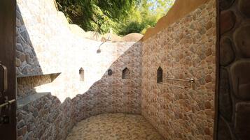Un bagno con pareti in pietra, una piccola finestra e una porta.